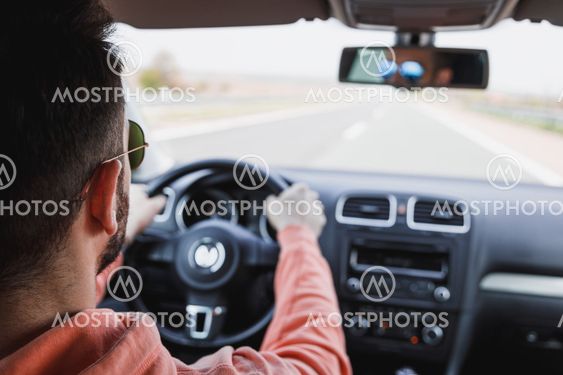 Young man driving a car, interior shot