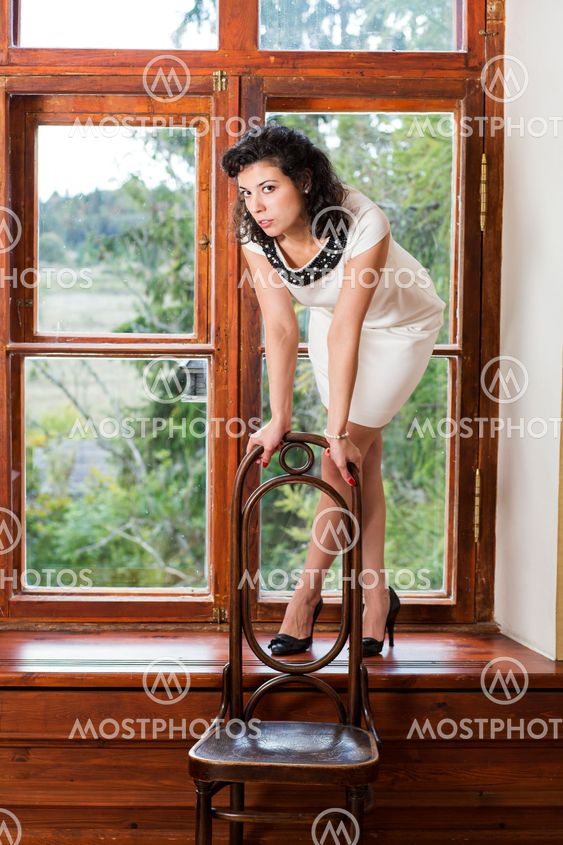 Woman on sill rely on chair back