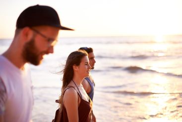 Friends, sunset and walk at ocean for travel, summer...