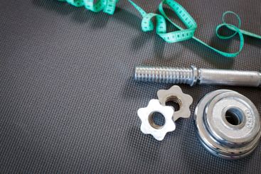 Fitness concept with dumbbells and measuring tape