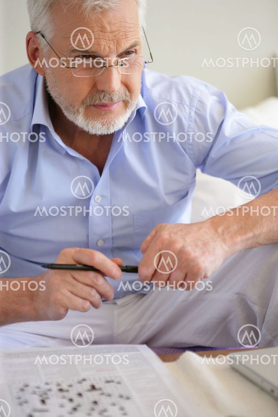 Man completing crossword puzzle