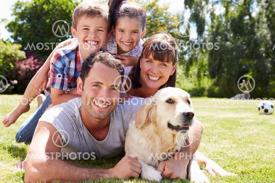 Family Relaxing In Garden With Pet Dog