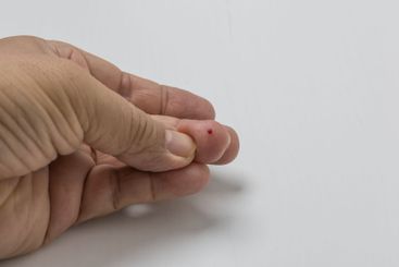 Finger with a drop of blood for measuring blood sugar level