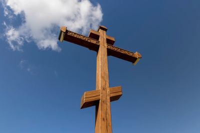 wooden christian cross on a blue sky background