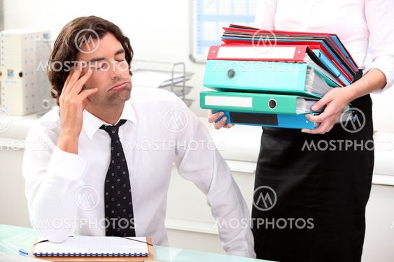 Office worker overwhelmed by load of work
