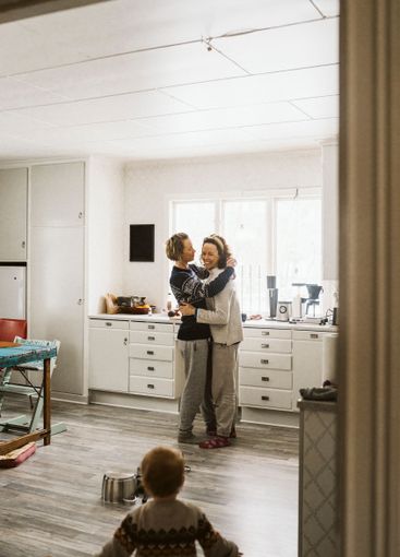 Mature woman standing with girlfriend looking at daughter...