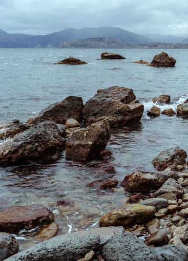 Rocky shoreline at a coastal area with gentle waves and...