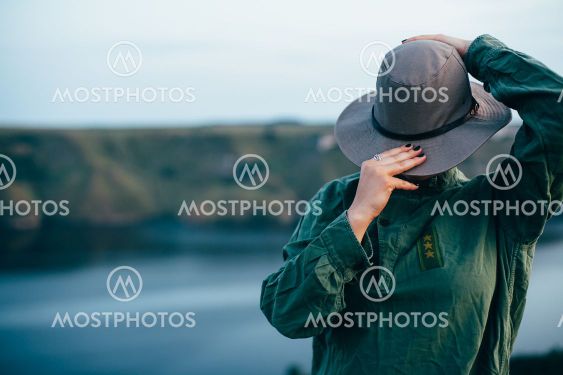 A girl stands on top of a mountain against the backdrop...