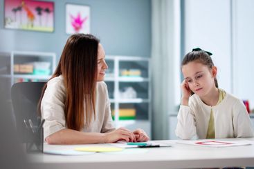 Caring therapist comforts depressed child during...