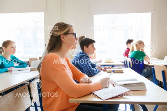 group of students with books at school lesson