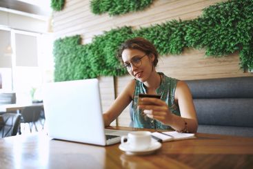 Cafe, smile and businesswoman with laptop for credit...