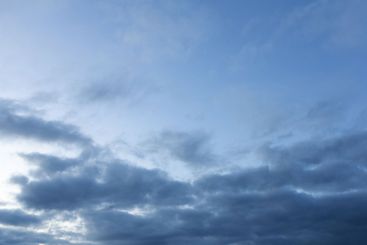 Evening moody blue sky with clouds and sunlight