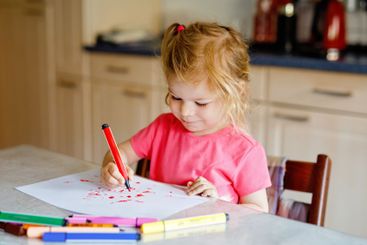 Cute little baby toddler girl painting with colorful...