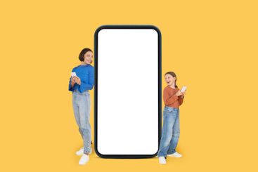 Cheerful mother and daughter standing together beside a...