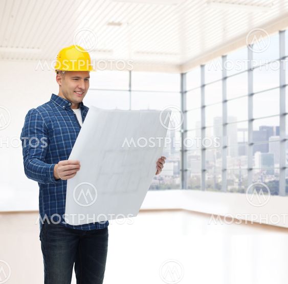 smiling male builder in helmet with blueprint