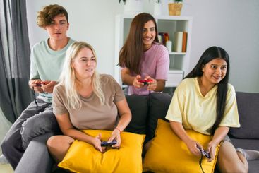 Cheerful group of friends playing video games together...
