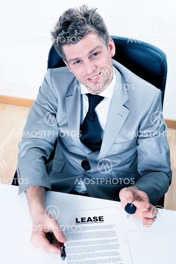 handsome real estate agent proposes to sign a lease with handing over the keys