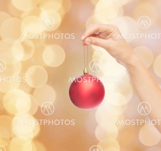 close up of woman in sweater with christmas ball