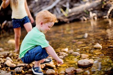 Children, river and playing with water, boy and fun on...