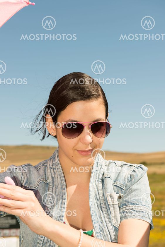 Beautiful adult smelling flowers on sunny field enjoying herself