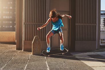 Skateboard, city and girl with flip in air for jump...