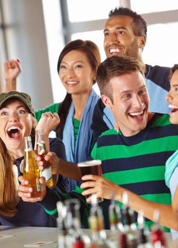 Beer, celebration and friends in pub with sports, game...