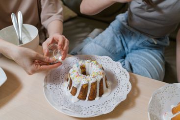 Mother and daughter decorating Easter cakes together.