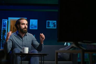 Upset fan watching live sports event on TV in living...