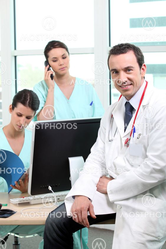 Doctor sitting with nurses at a computer