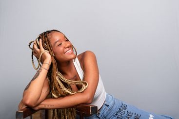 Portrait of a smiling brunette woman with braids in her...