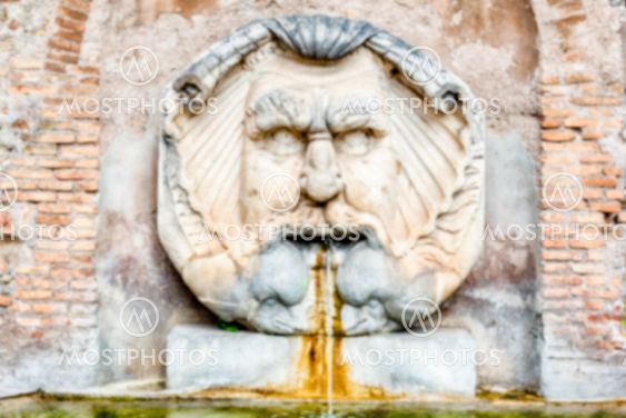 Defocused background of fountain with mask, Rome, Italy