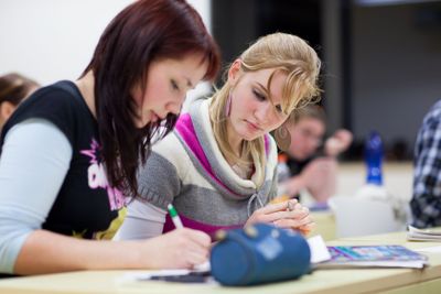 pretty, female college student sitting in a classroom...