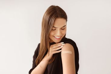 Caucasian woman patient showing shoulder with band aid...