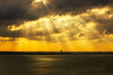 Dramatic golden sunlight breaking through heavy clouds