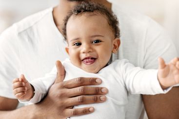 Closeup Portrait Of Adorable Black Baby Boy Relaxing In...