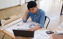 Architect and engineer working on a laptop with...