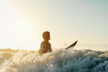 Surf, water splash and blue sky with a sports man in the...