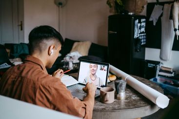 Male freelancer doing video call with female colleague on...