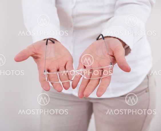 Woman holding a pair of spectacles