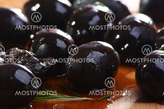 Black olives on a wooden table.