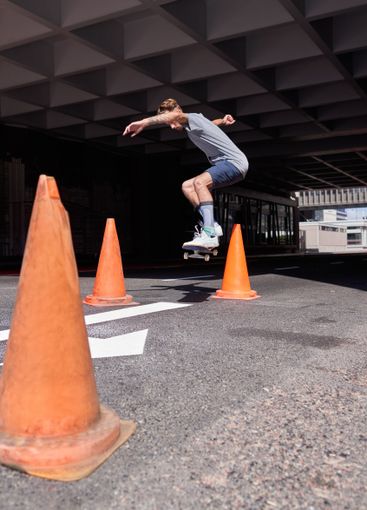 City, jump and man with skateboard, stunt and skills for...