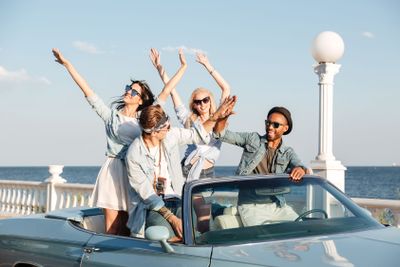 Cheerful people giving high five and having fun in car