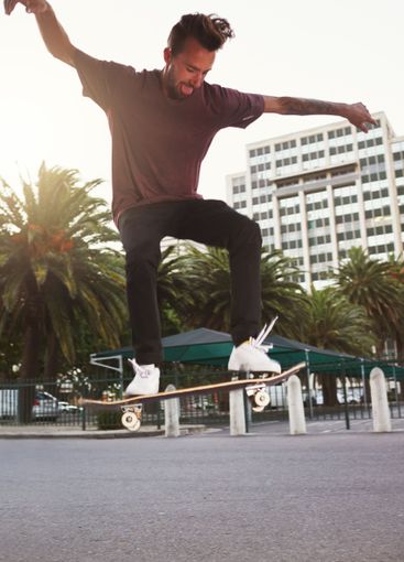 Skateboard, city and man with ollie trick in air for...