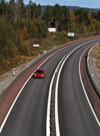 Ensam röd bil på väg