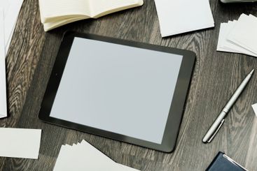 Digital workspace with tablet, blank paper, and...