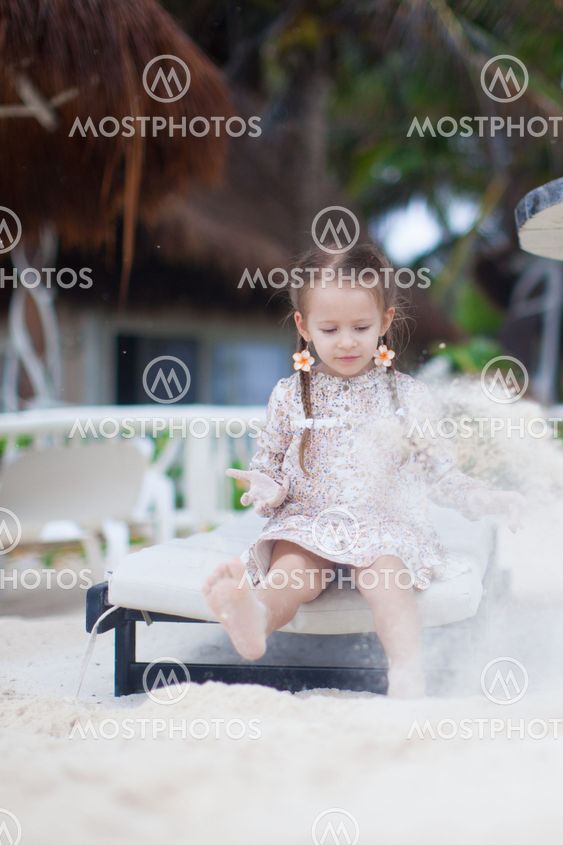 adorable little girl on the beach playing with sand