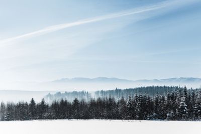 blue cloudy sky with sunshine and winter snowy mountain...