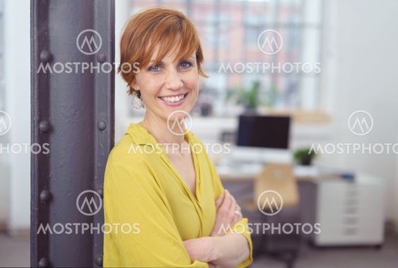Female with folded arms in small office