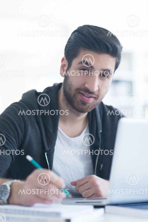 student in school library using laptop for research
