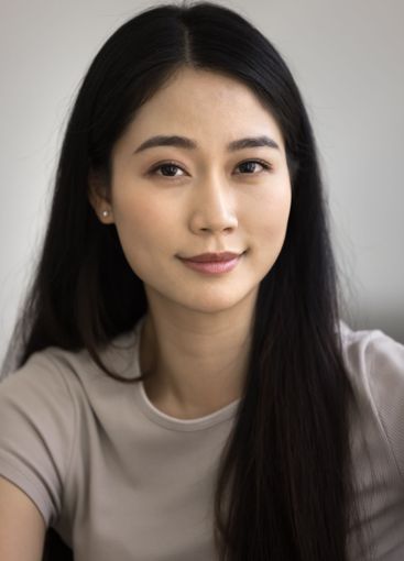 Vertical shot of beautiful Asian woman looking at camera